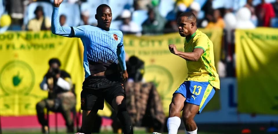 Player kicking ball while opponent defends during match