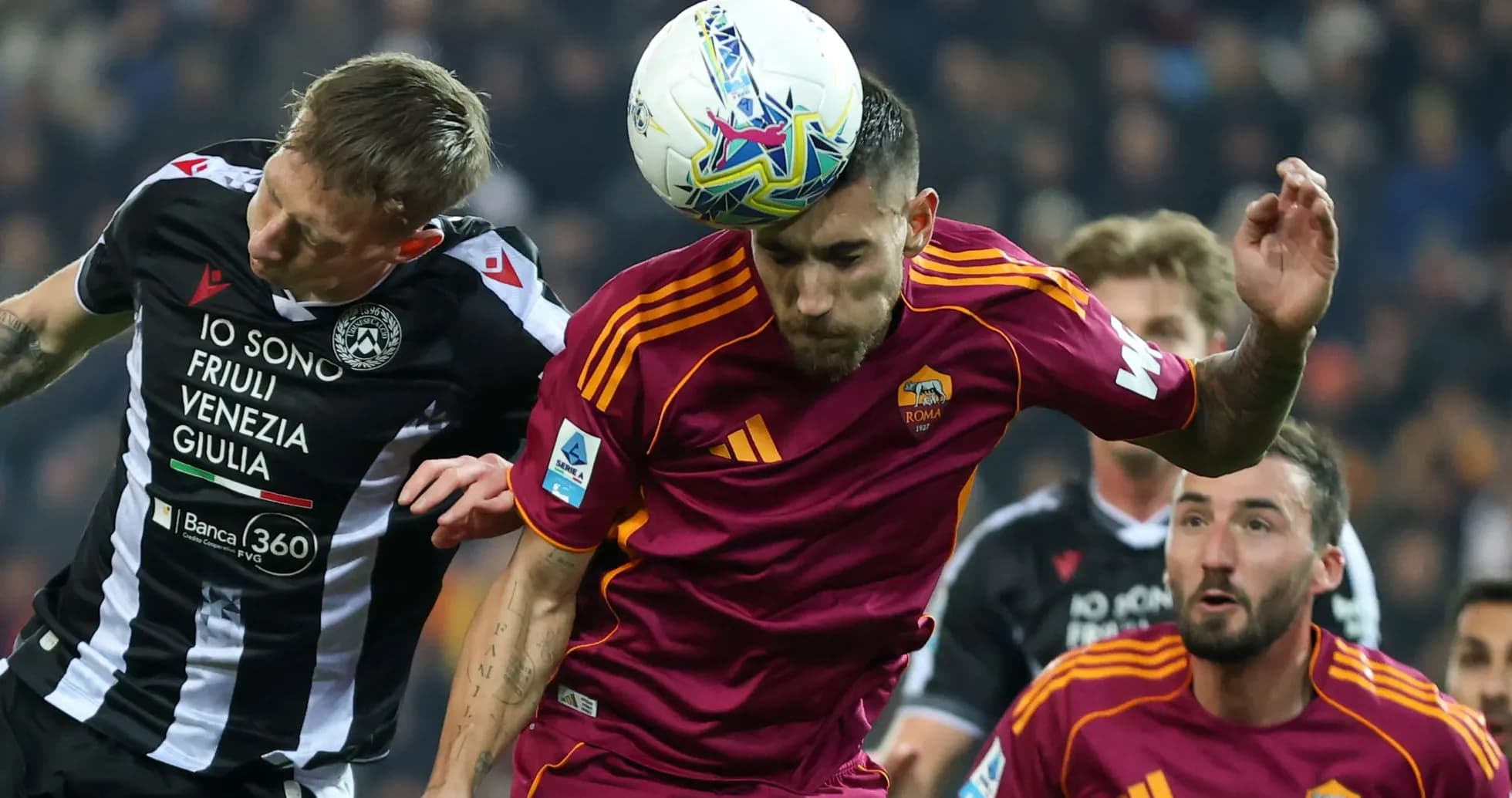 Udinese player challenges AS Roma player for header