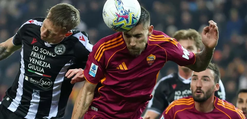 Udinese player challenges AS Roma player for header