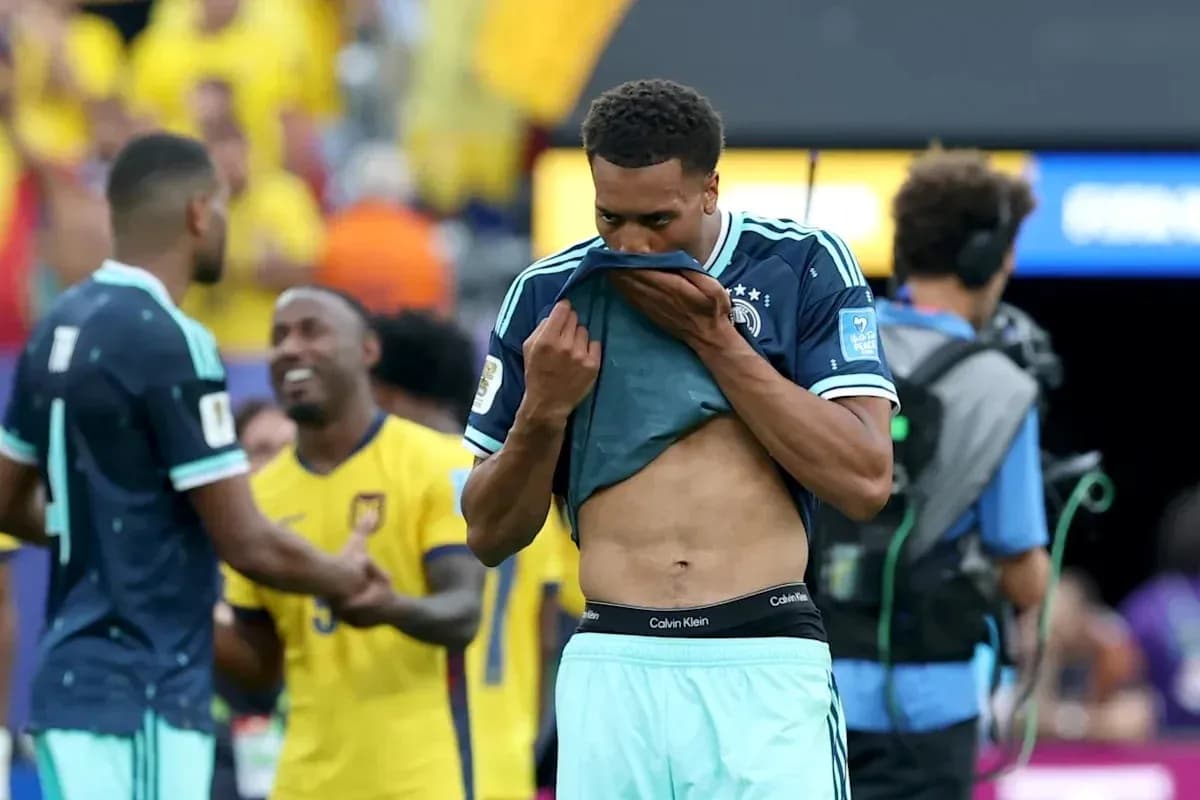 Player pulling up shirt after match, teammates in background