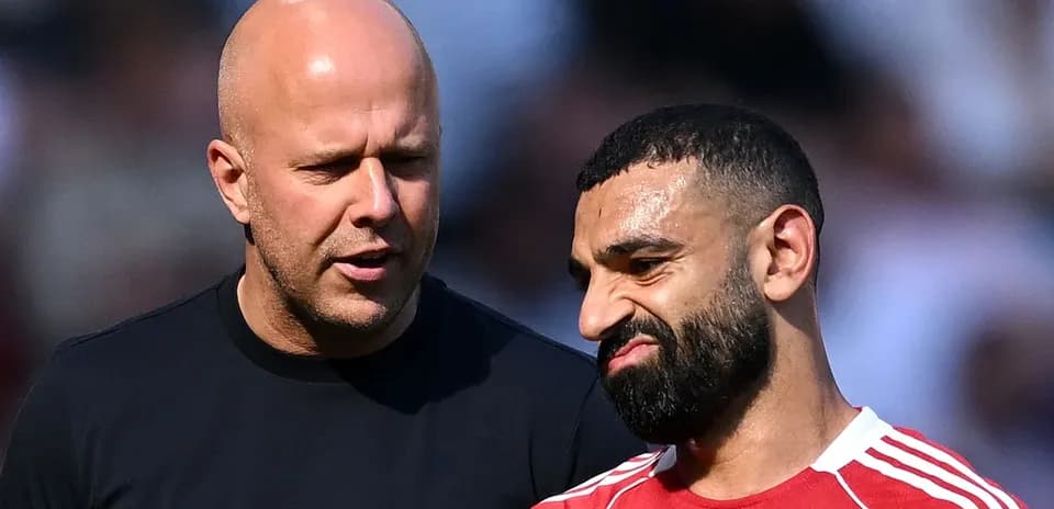 Two men conversing on the pitch during warm-up