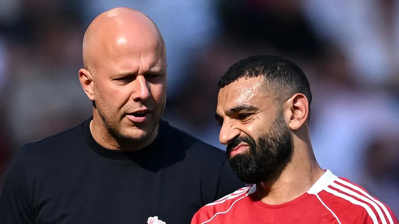Two men conversing on the pitch during warm-up