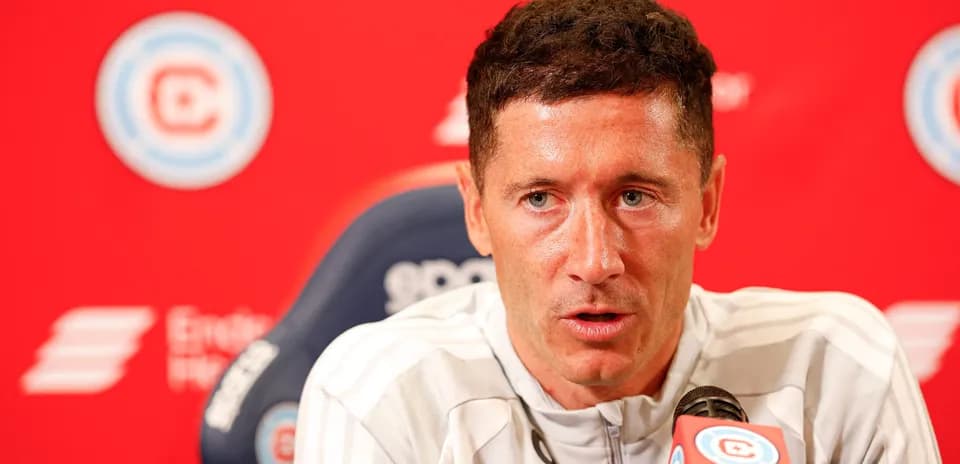 Player speaking at press conference with red backdrop