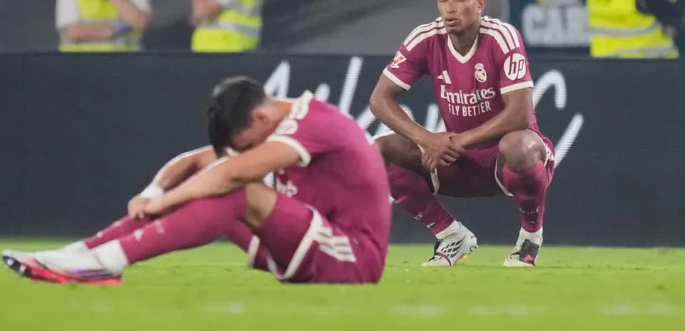 Two Real Madrid players sitting on the field