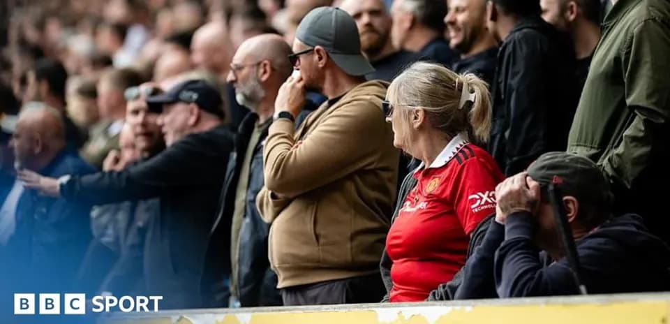Fans watching match in stadium stands