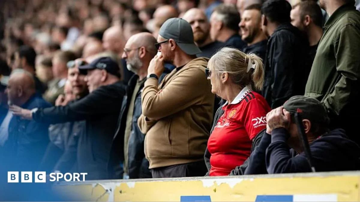 Fans watching match in stadium stands