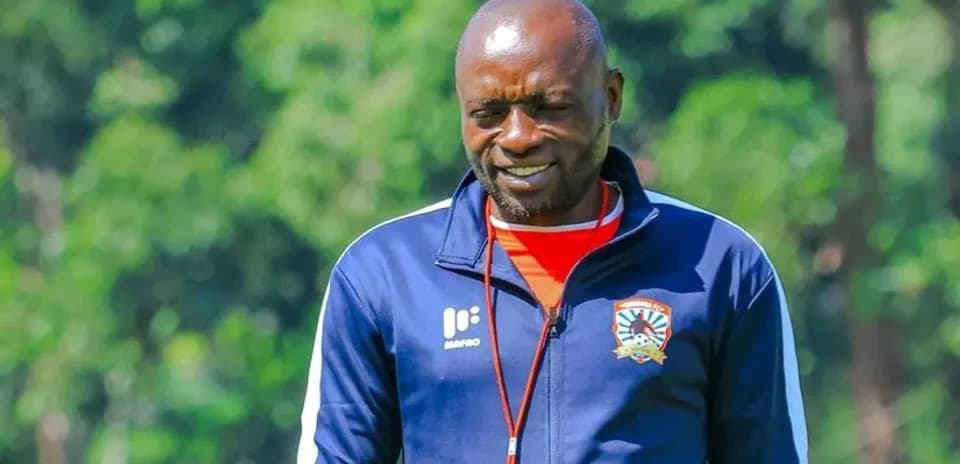Coach walking on training ground with smile