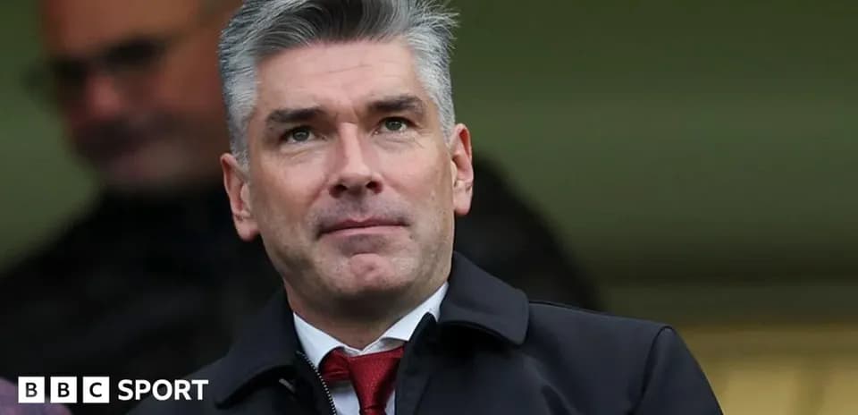Man in a suit observing a sporting event