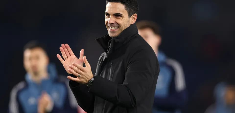 Coach clapping during team celebration on pitch
