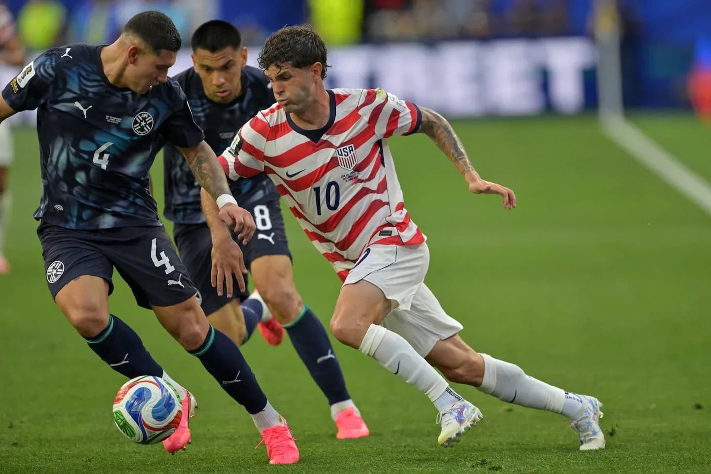 Christian Pulisic dribbling past Paraguayan defenders