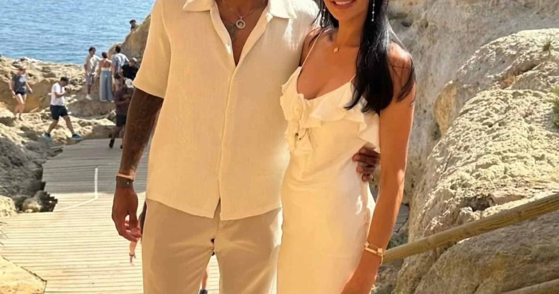 Couple posing near rocky coastline with ocean view