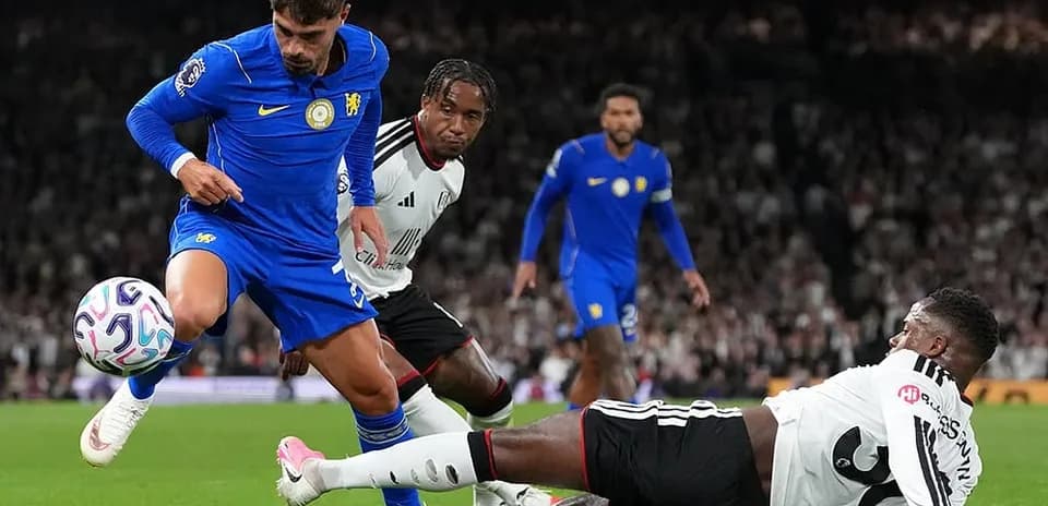 Chelsea player dribbling past Fulham defenders