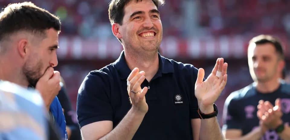 Coach applauding with players in the background