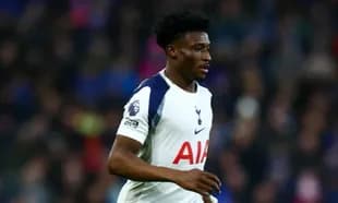 Player in Tottenham jersey running on the pitch