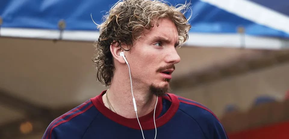 Athlete wearing earbuds and looking away outdoors