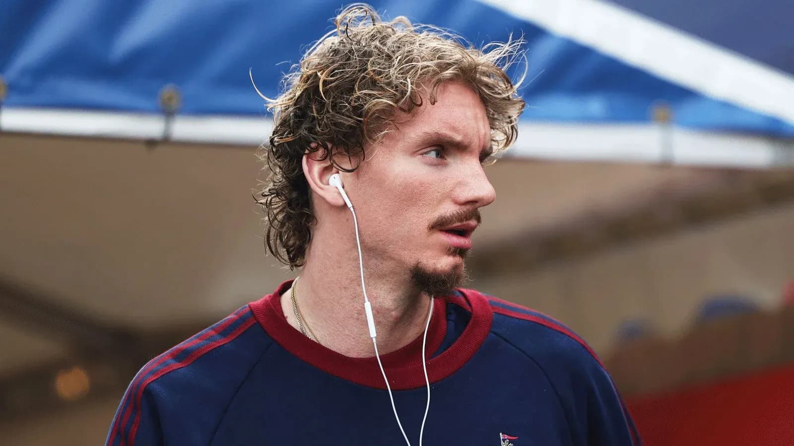 Athlete wearing earbuds and looking away outdoors
