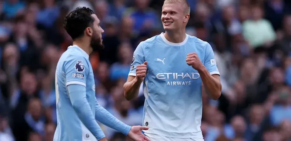 Manchester City players celebrating a goal on pitch