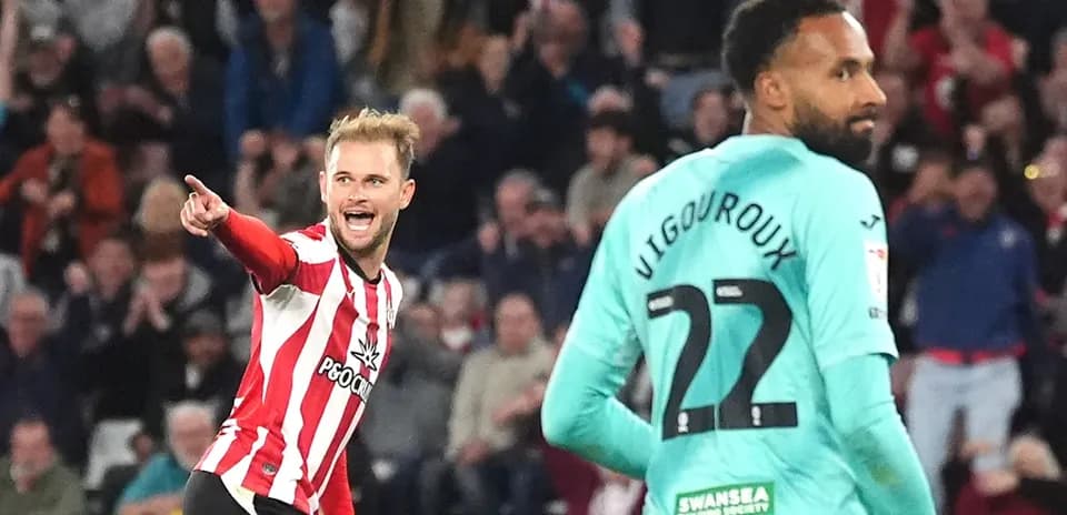 Player celebrating a goal against opposing goalkeeper