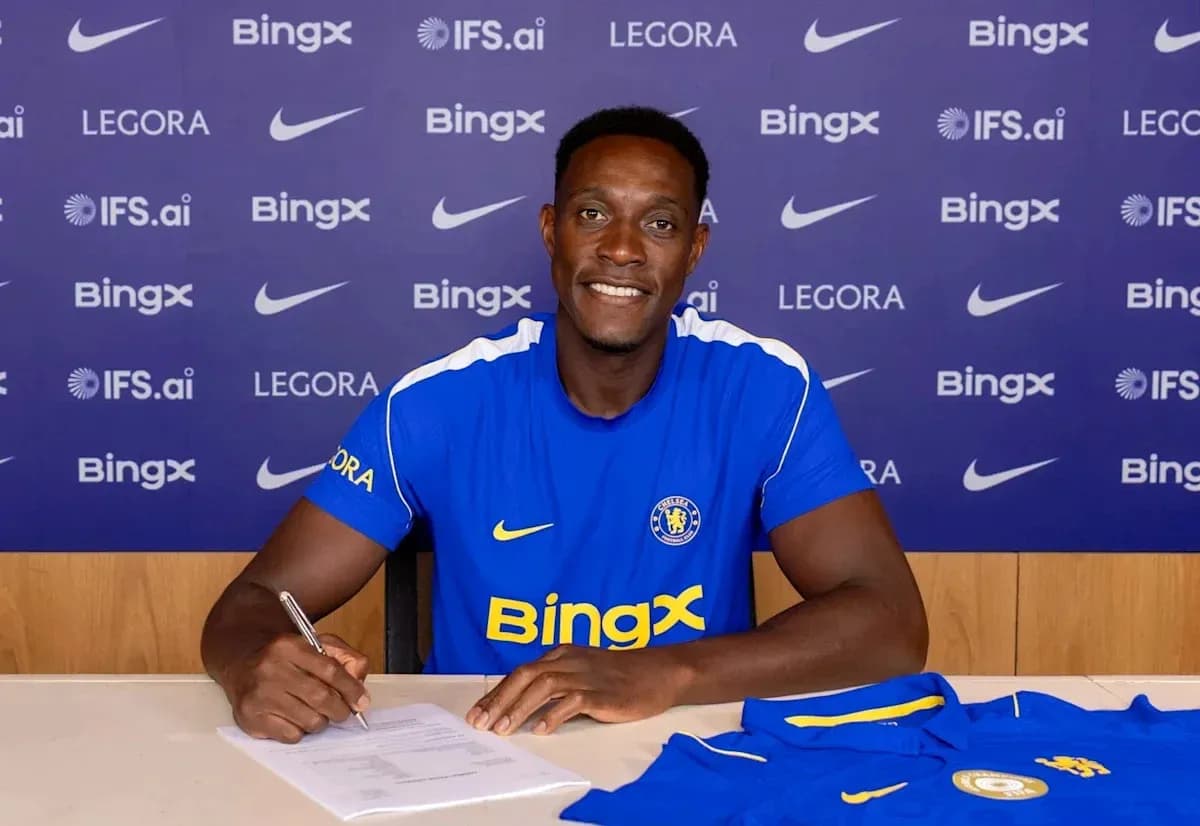 Player signing contract at press conference table