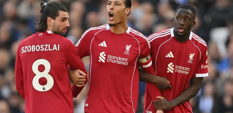 Three Liverpool players discussing during a match