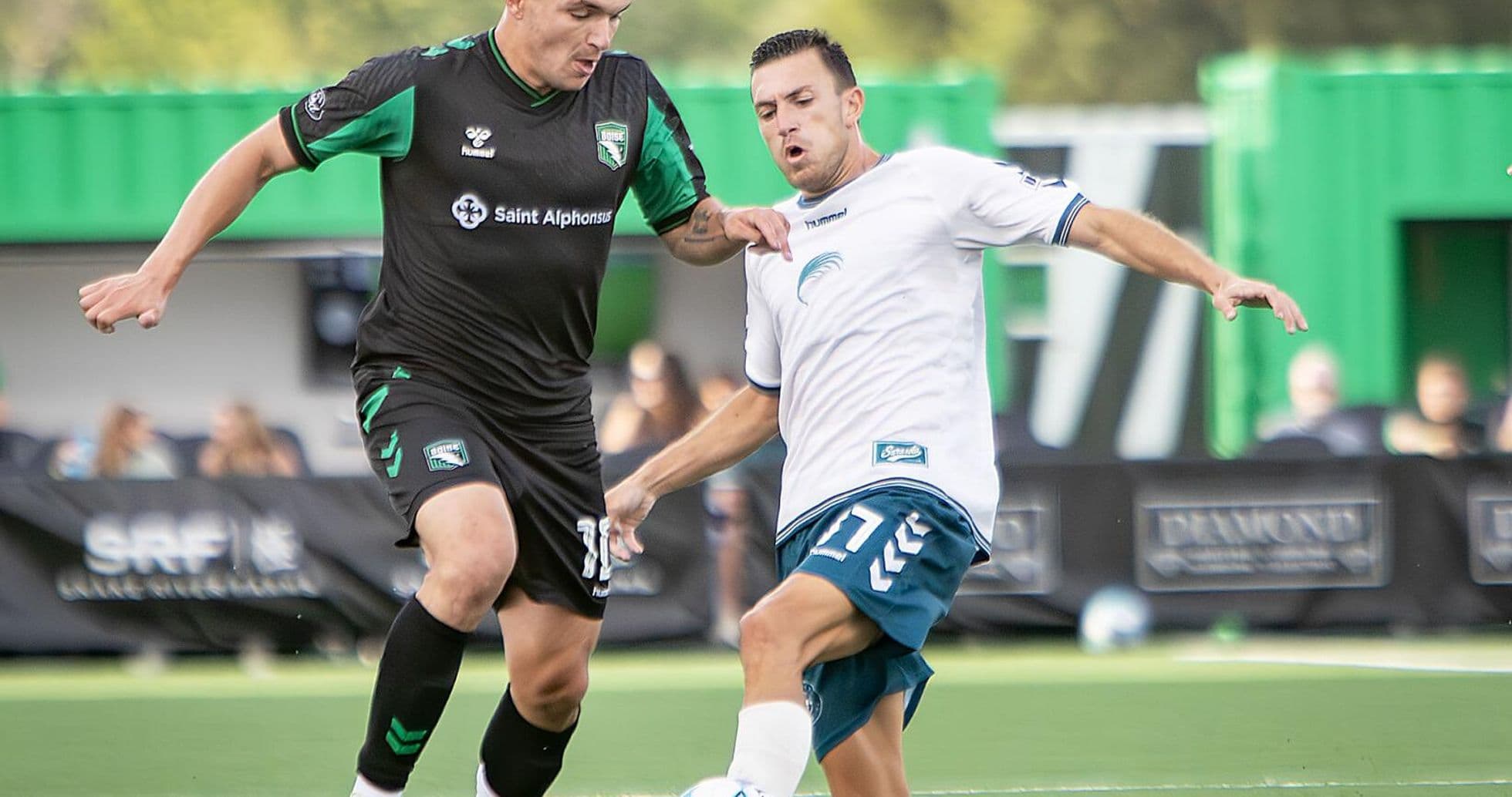 Two players competing for the ball in football match
