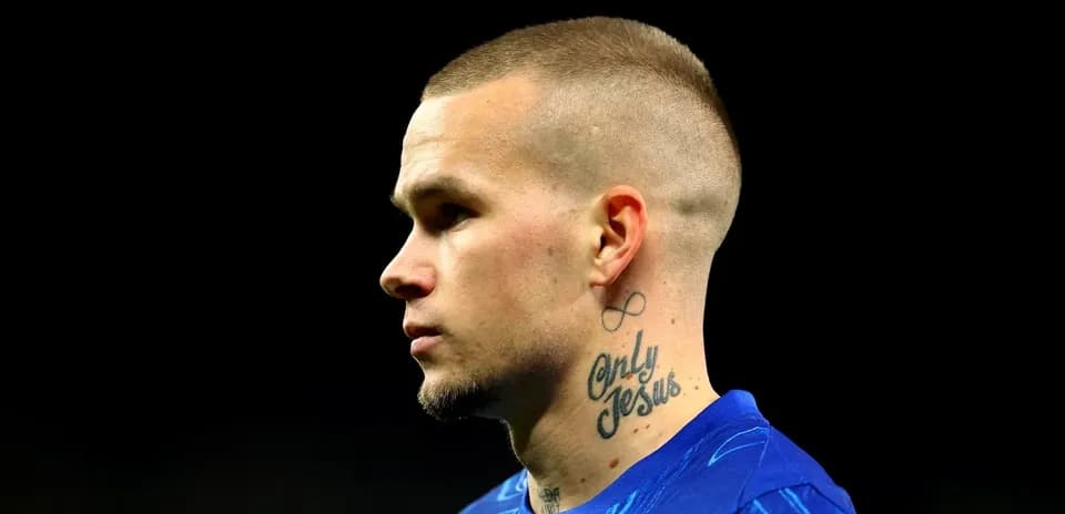 Player with tattoos wearing blue sports jersey