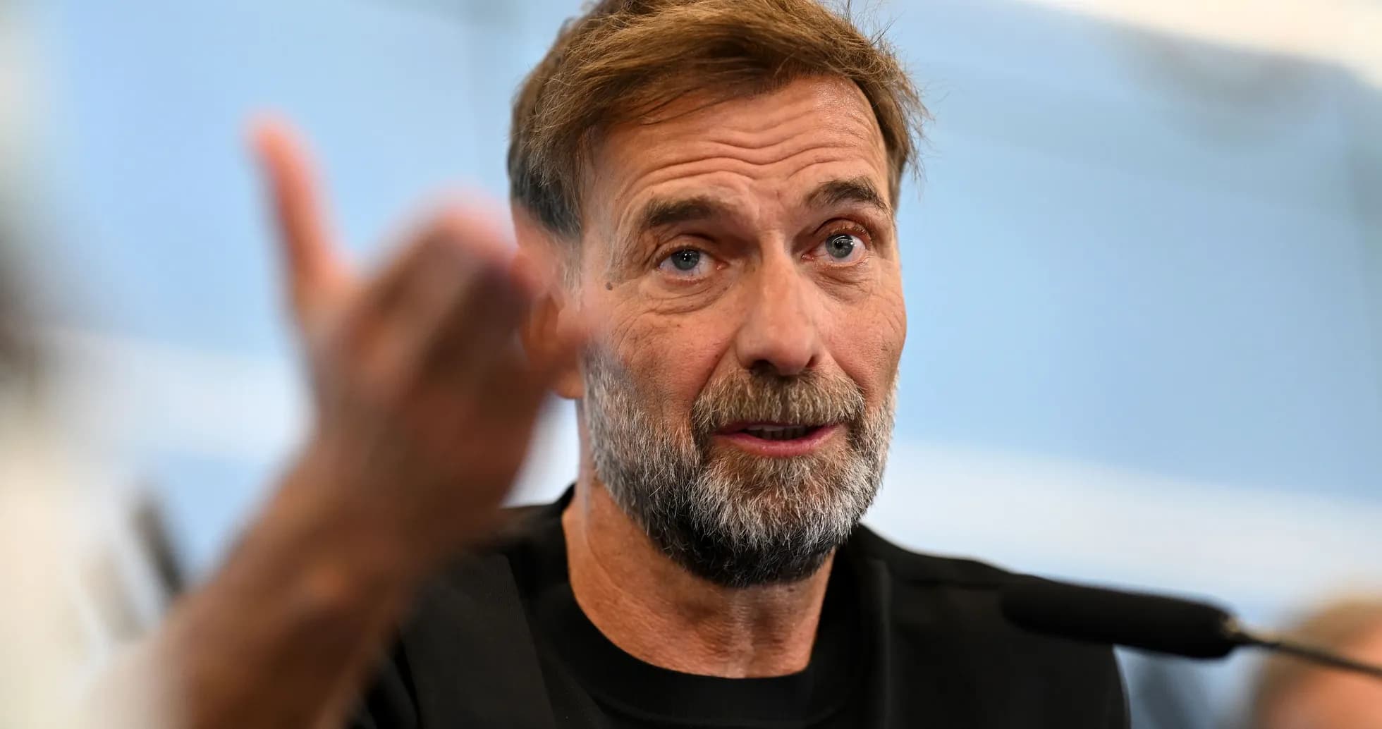 Manager speaking at press conference with microphone