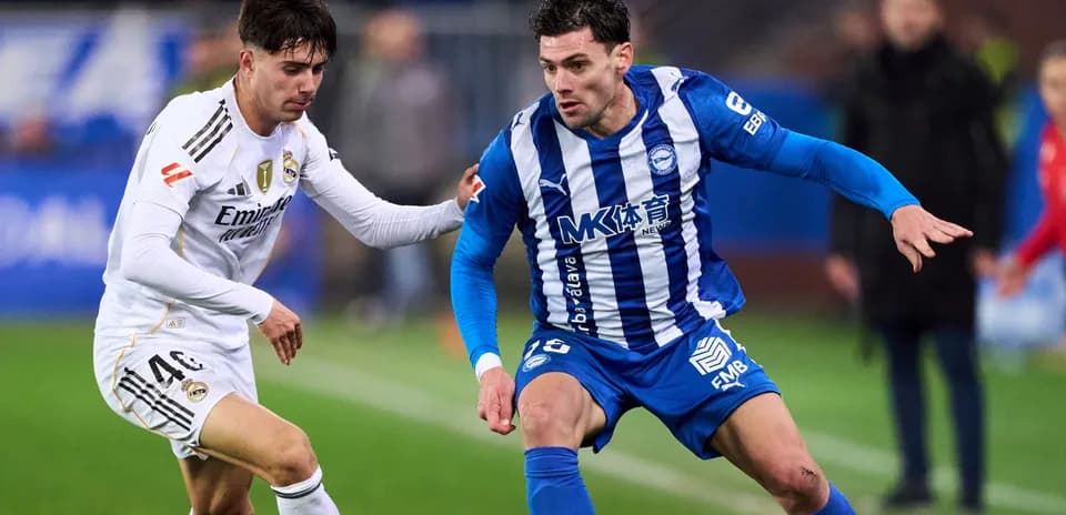 Two football players competing for possession of the ball