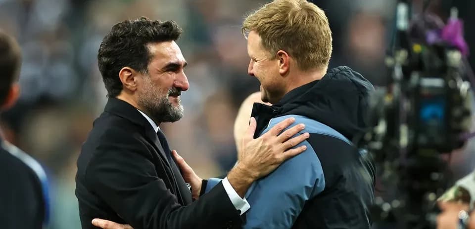 Two football coaches embracing after a match