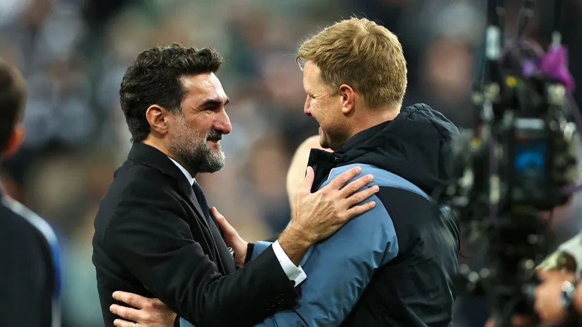 Two football coaches embracing after a match
