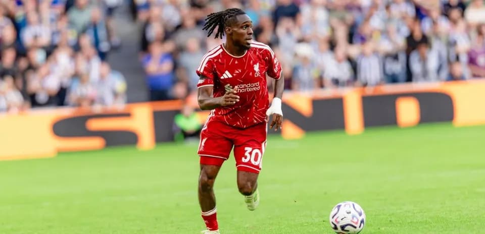 Player in red kit running with ball during match