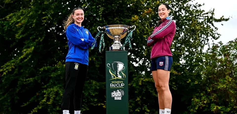 Two female players posing with Women's FAI Cup trophy