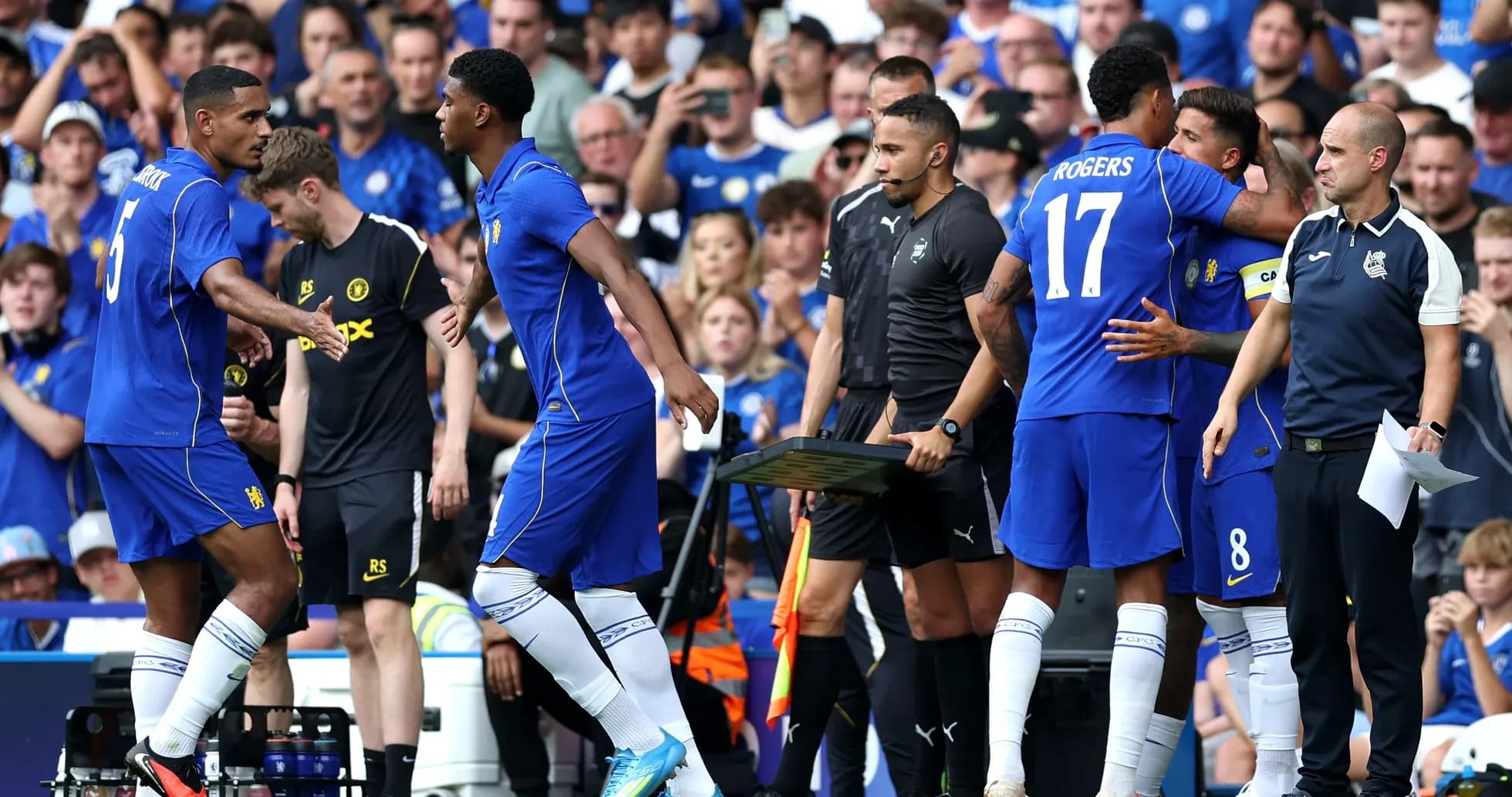 Players exchanging greetings during a substitution on pitch