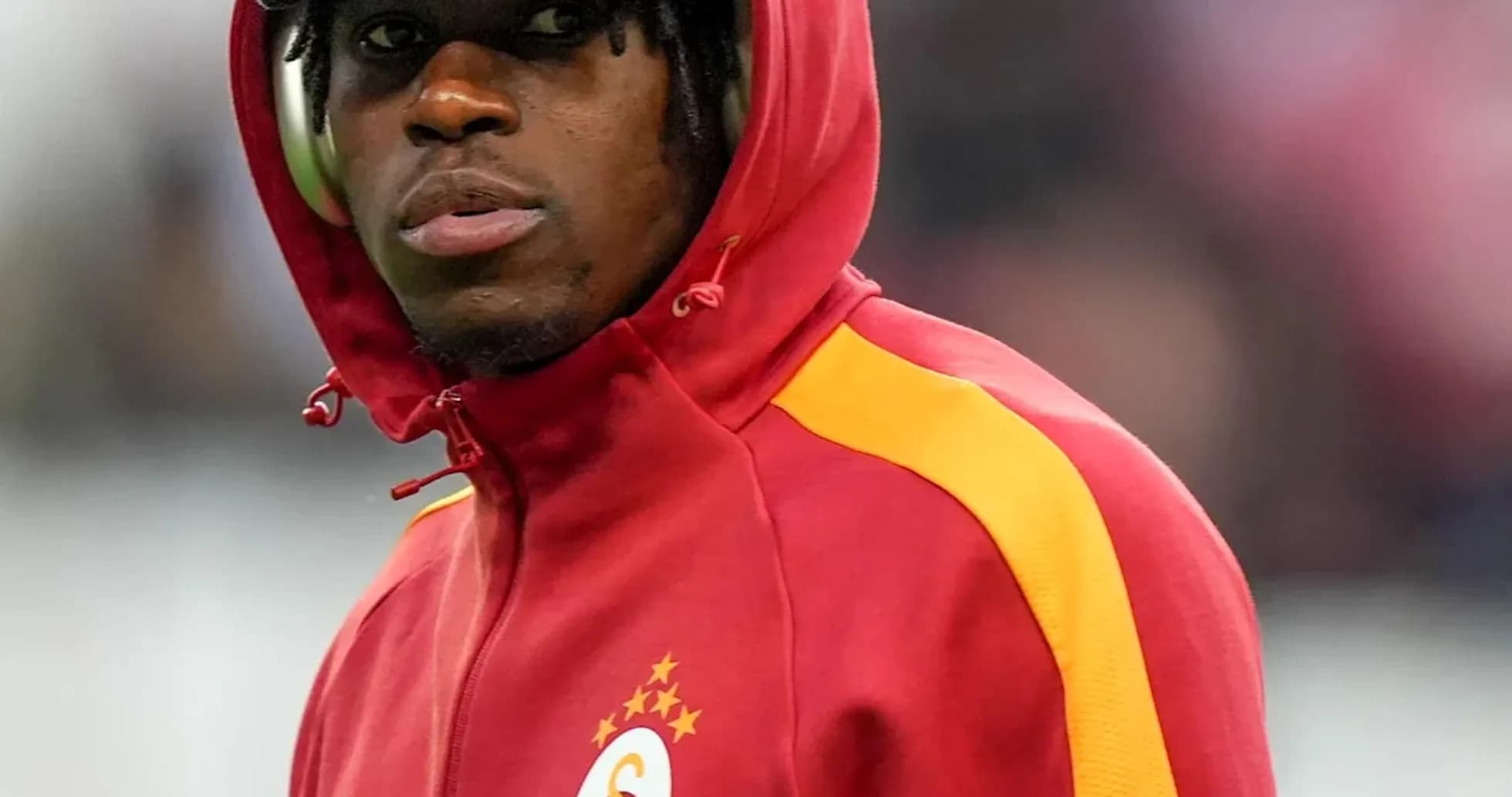 Player wearing a red Galatasaray tracksuit on field