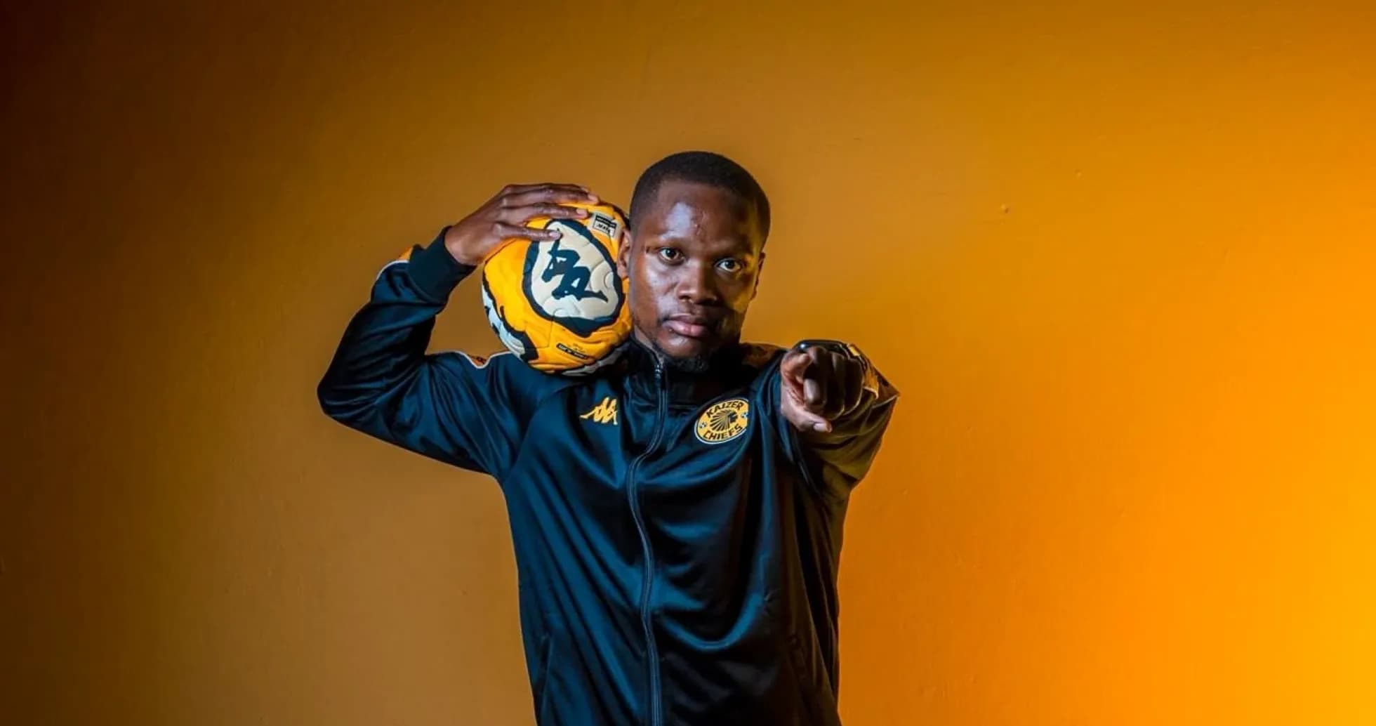 Player in Kaizer Chiefs jacket holding soccer ball