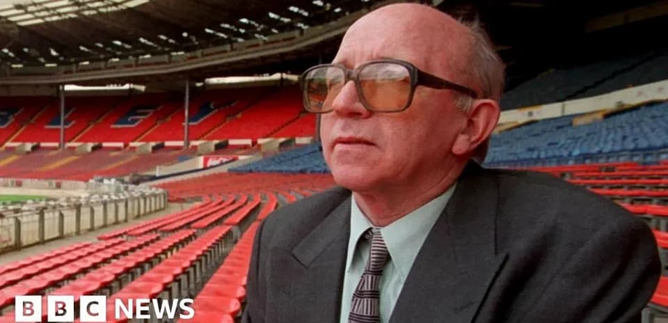 Man seated in empty stadium stands at Wembley