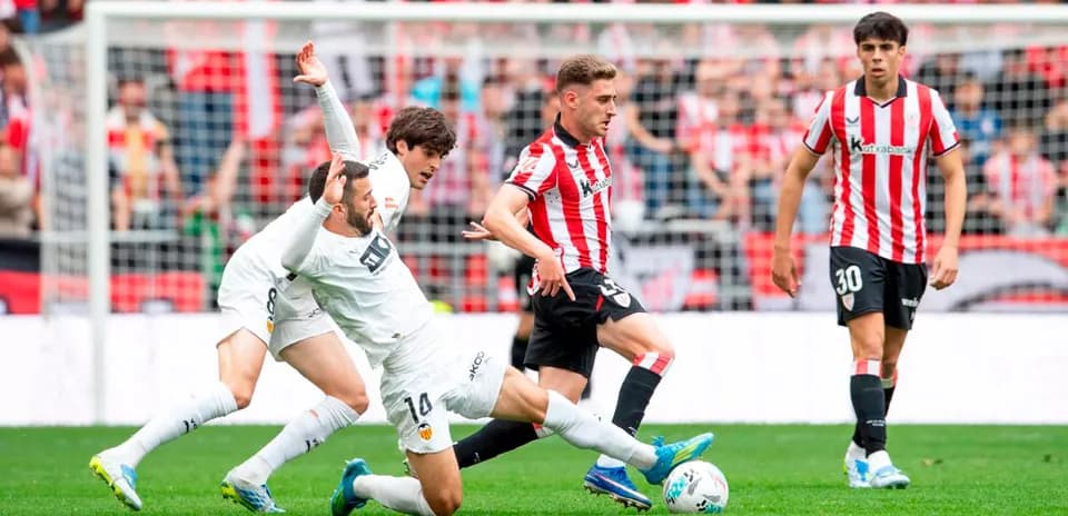 Athletic Club player dribbling against Valencia defenders
