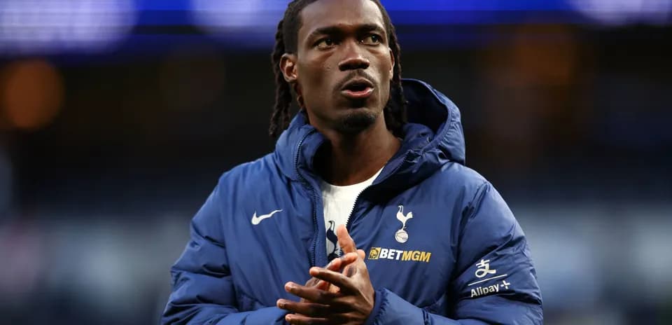 Player wearing Tottenham jacket on the field