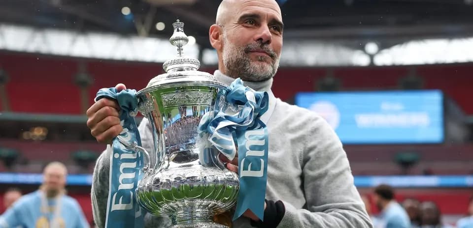 Manager holding trophy at Wembley Stadium celebration