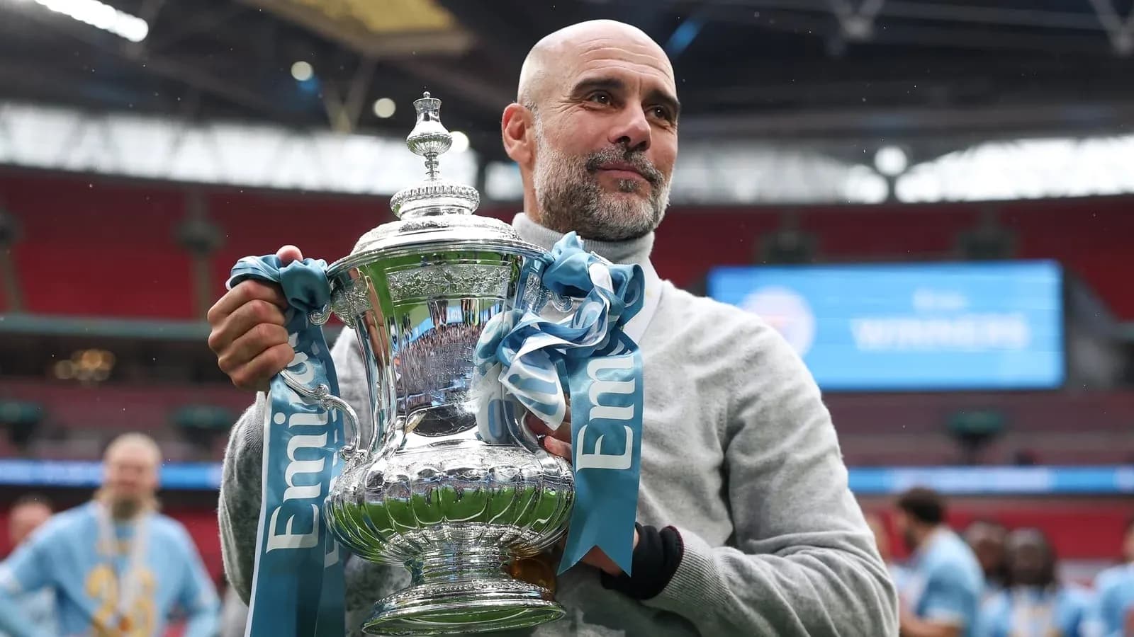 Manager holding trophy at Wembley Stadium celebration