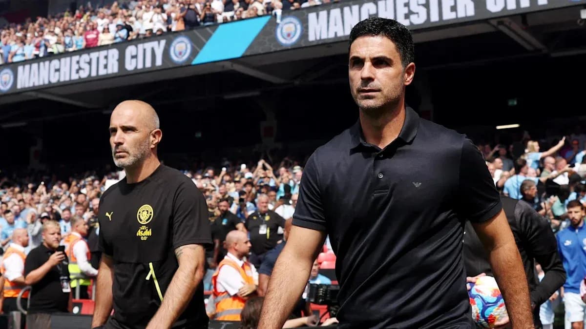 Two coaches walking on the pitch before match