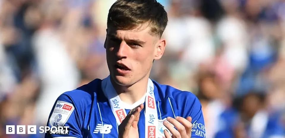 Player wearing blue jersey applauding fans