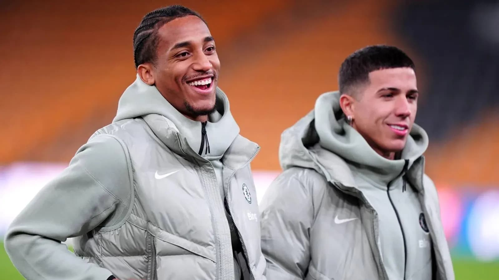 Two players smiling in training jackets before match
