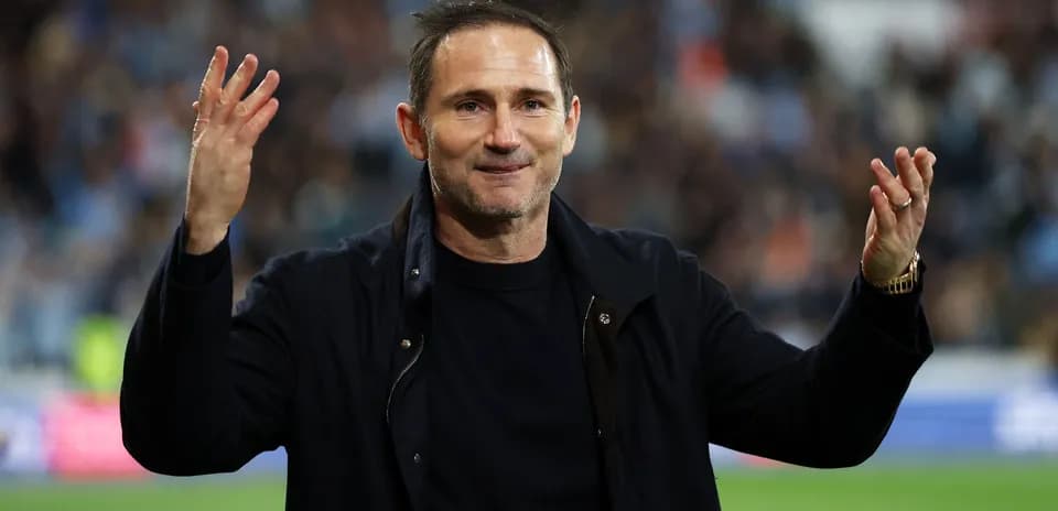 Manager gesturing to fans during a match