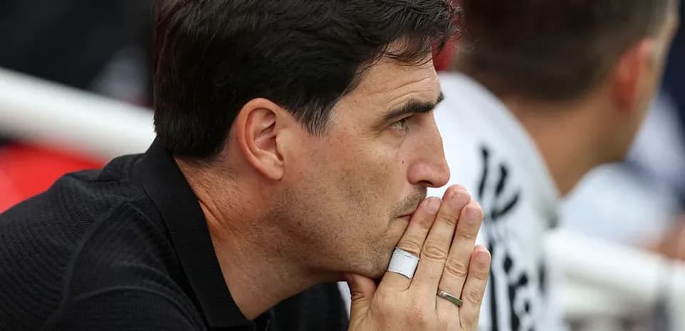 Coach deep in thought during match on sidelines