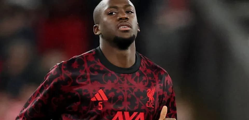Player in Liverpool FC kit warming up on pitch
