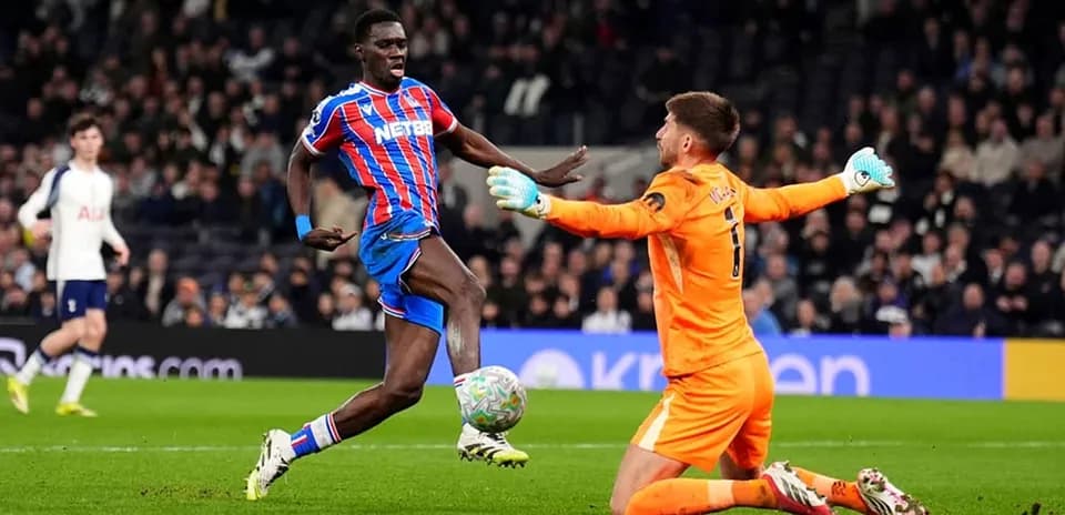 Crystal Palace player challenging Tottenham goalkeeper
