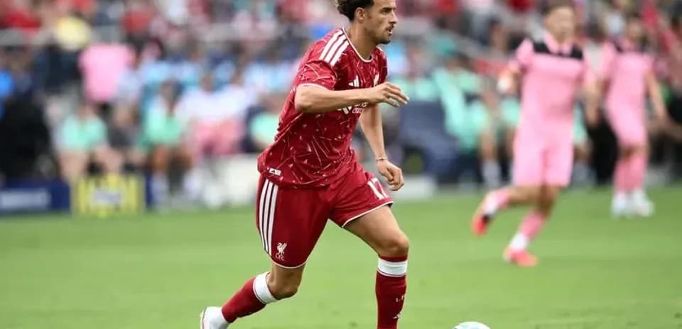 Player in red jersey dribbling ball on field