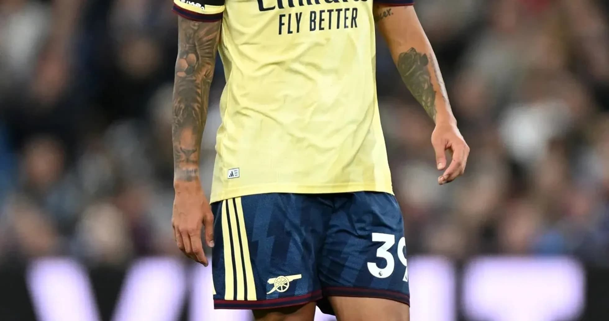 Player in Arsenal kit walking on the pitch