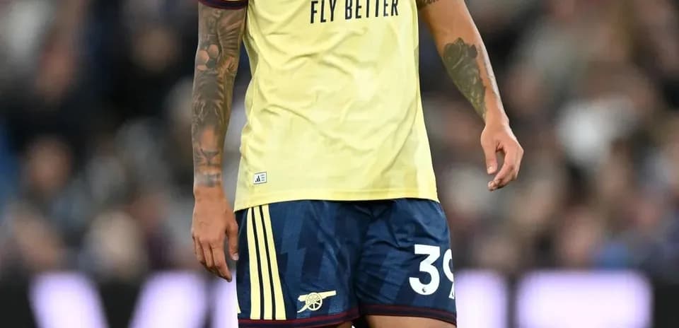 Player in Arsenal kit walking on the pitch